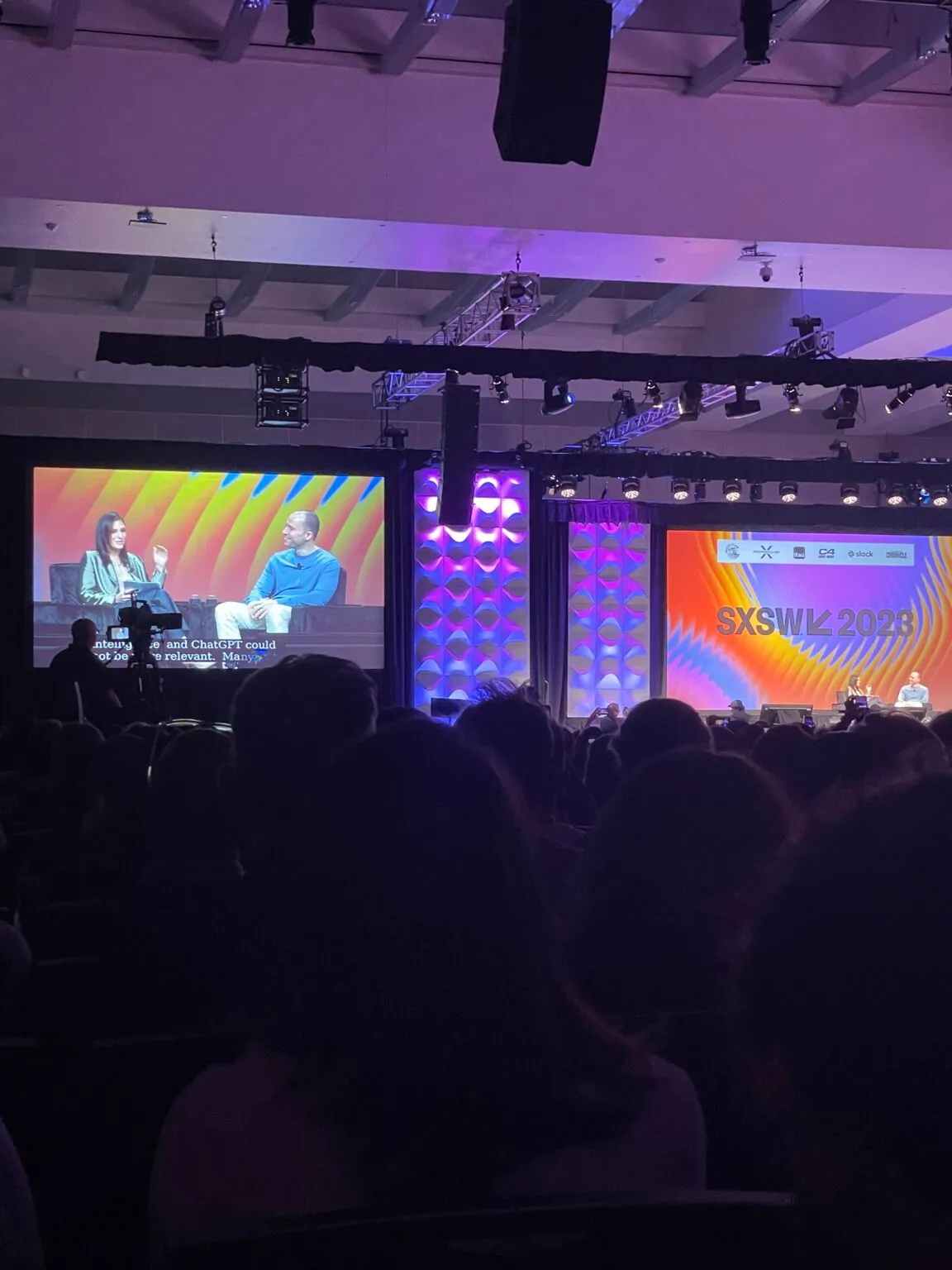 A discussion on stage at SXSW 2023, photographed from the audience