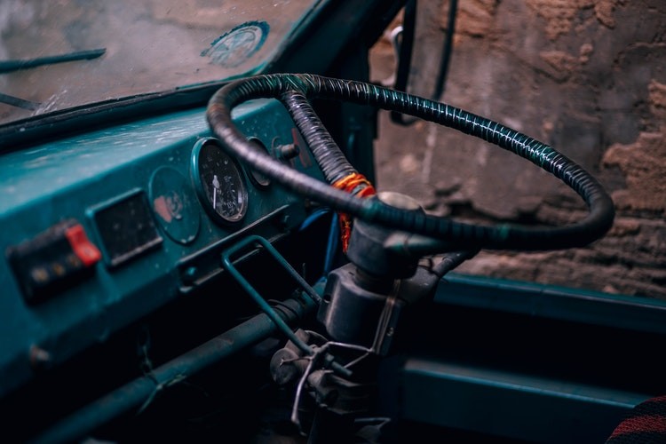 The steering wheel and dashboard of an Indian vehicle.